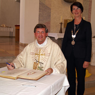 Bild vergrern: Pfarrer Peter Husler und Brgermeisterin Dr. Susanne Plank beim Eintrag ins Goldene Buch. 