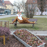 Bild vergrößern: Der Maxhütter Osterhase rastet auf der Bank vor dem Rathaus