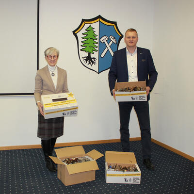 Bild vergrößern: Auf dem Foto zeigen Erster Bürgermeister Rudolf Seidl und Claudia Sperl von der Information im Rathaus die Kartons mit den gespendeten Brillen.