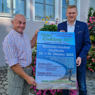 Bild vergrern: NaturEinKlang 2022 - Das Bild zeigt den Veranstalter Karl-Heinz Karmann (links) mit Erstem Brgermeister Rudolf Seidl bei der Plakatvorstellung vor dem Rathaus in Maxhtte-Haidhof.